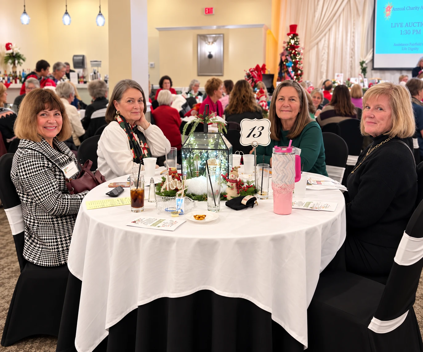 Fairfield Women members gathered around a decorated table during the annual Charity Auction